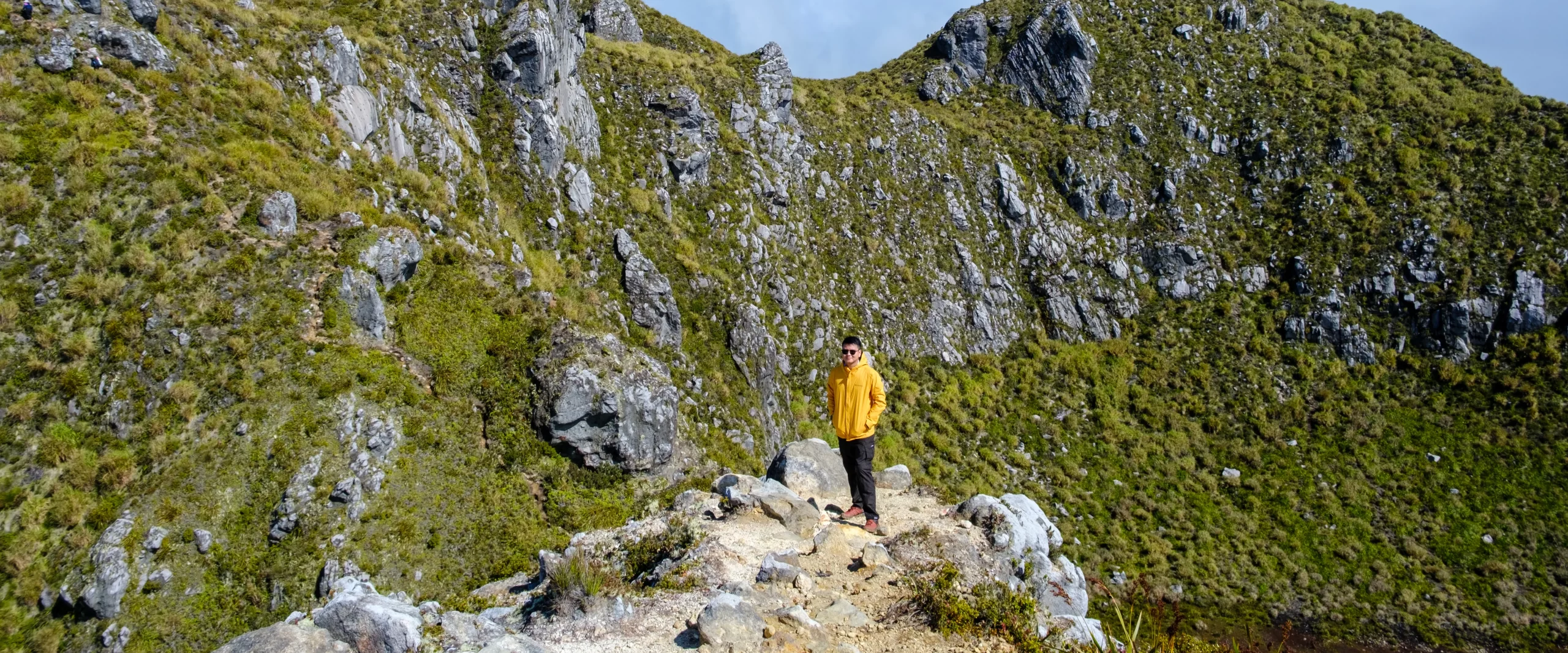 A hiker standing near Mt. Apo Summit featuring the crater lake on the background