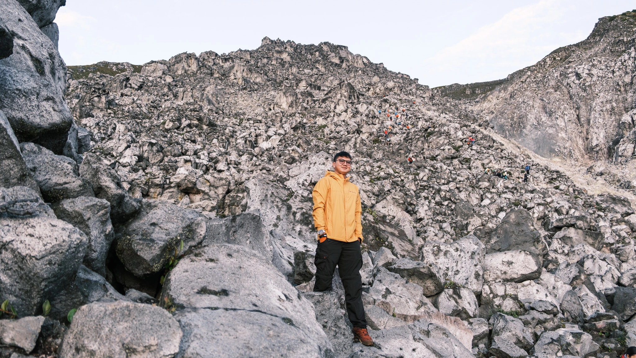 A hiker standing at a rock at Mt. Apo Boulder Face