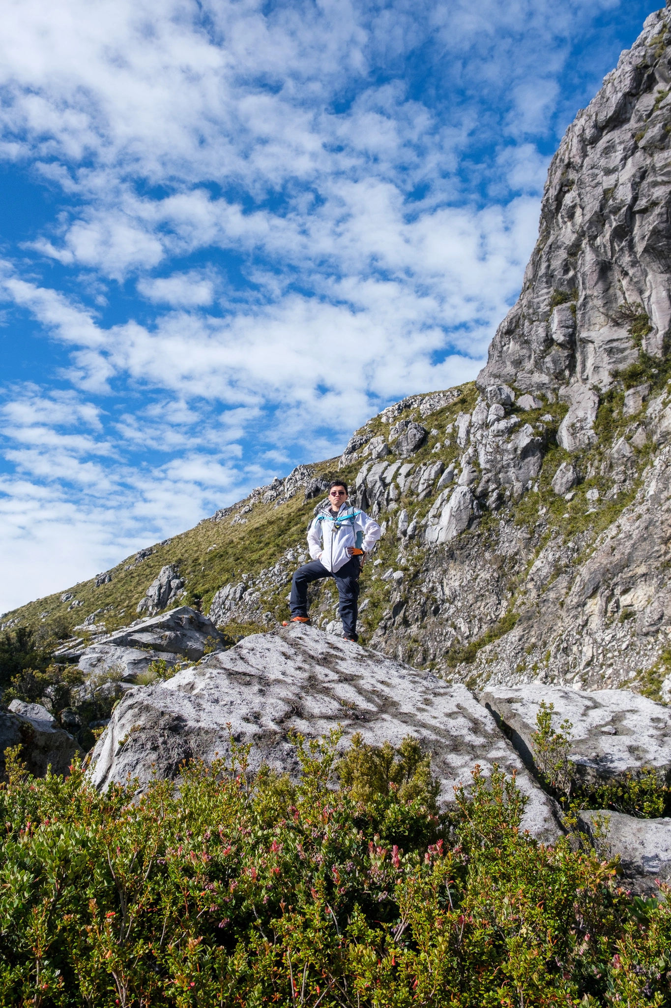 A hiker standing at a rock near the area of white sand at Mt. Apo