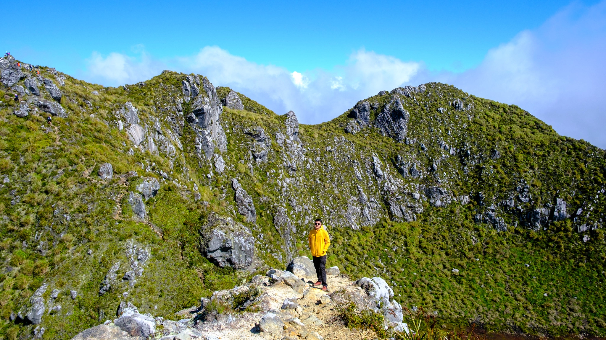 A hiker standing near the Mt. Apo summit with the crater lake as its background