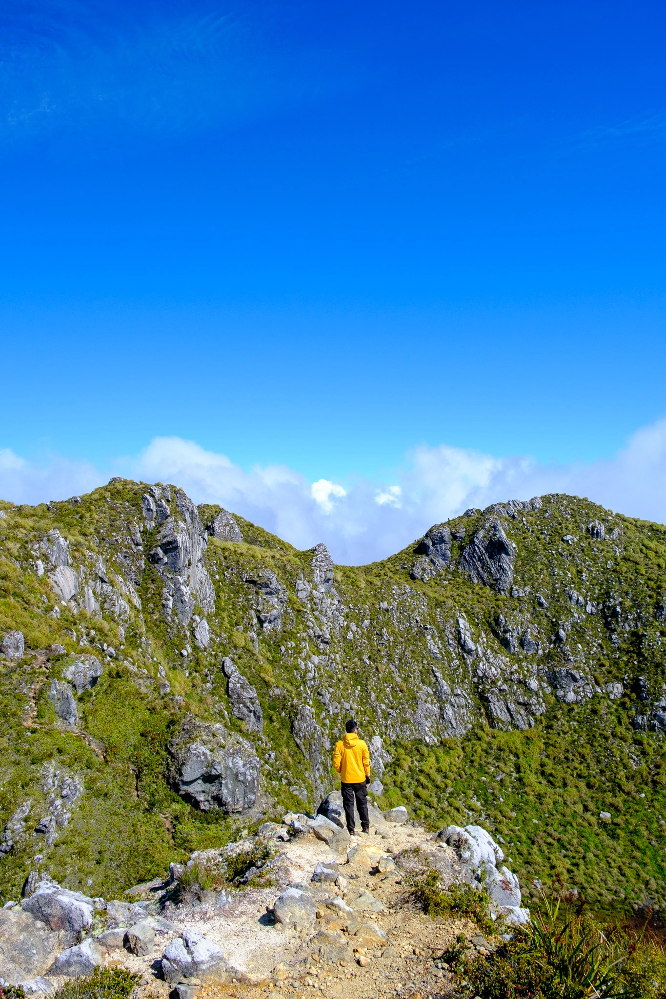 A hiker standing near the Mt. Apo summit with the crater lake as its background