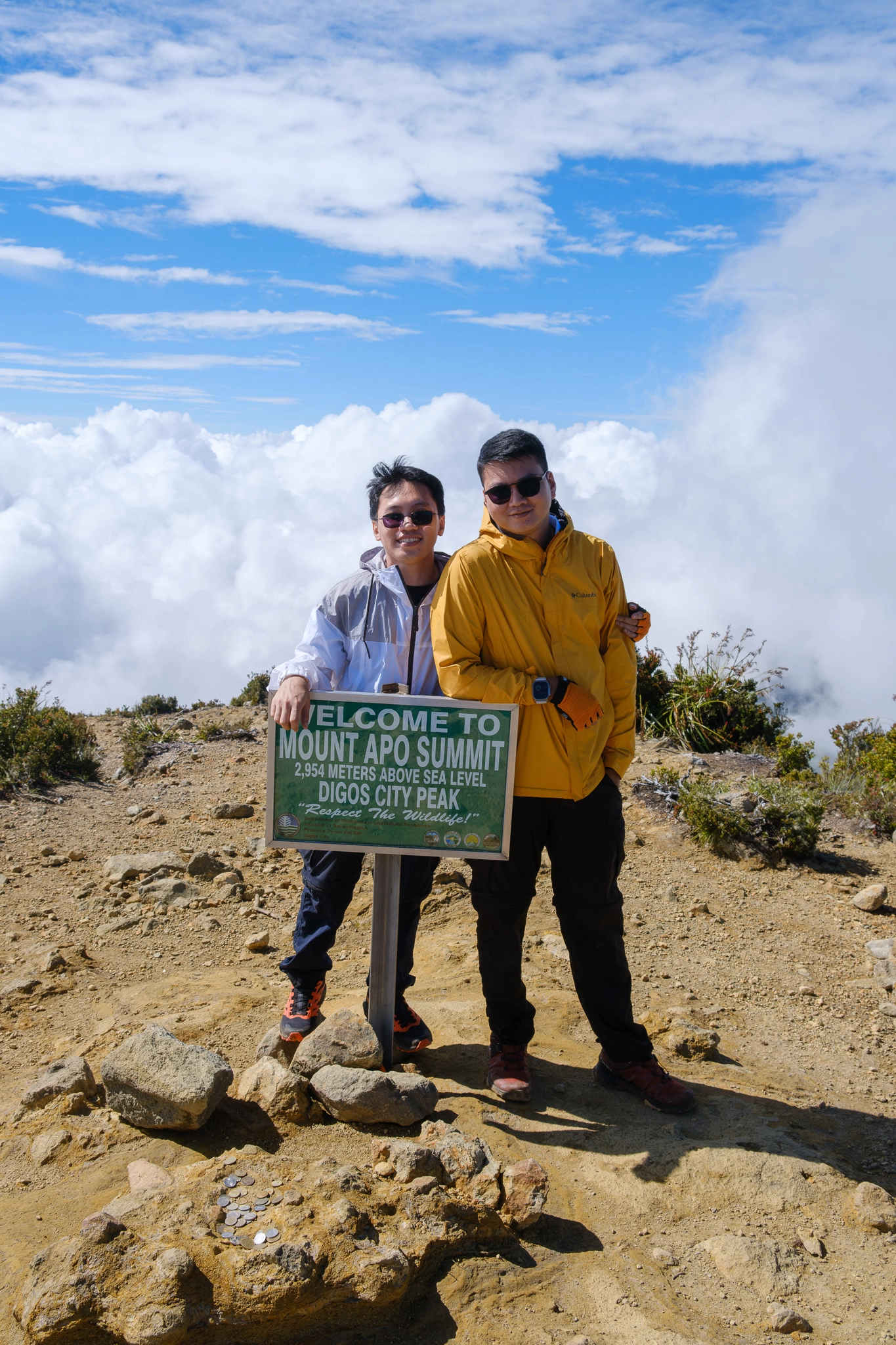 2 hikers smiling at the Mt. Apo summit sign